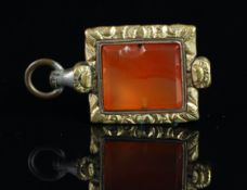 A broken watch key, set with a piece of orange agate