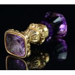 An amethyst and gold seal fob, set with a gold engraved handle, depicting flowers and foliage,