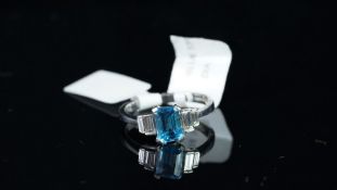 NEW OLD STOCK, UNWORN RETIRED STOCK - A blue topaz and diamond ring, central emerald cut blue