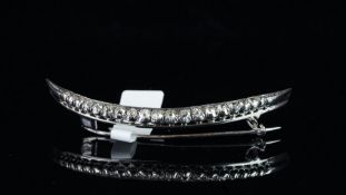 A late 19ct Century diamond crescent brooch, set with nineteen old cut diamonds, weighing an