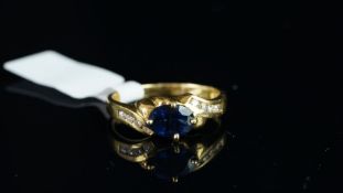 A sapphire and diamond ring, centrally set with an oval cut sapphire, weighing an estimated 1.
