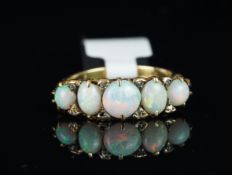 Five stone opal ring, central round cabochon cut opal to the centre, with an oval cabochon cut