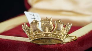 Yellow metal crown brooch, stamped 9ct, with a safety chain, base metal pin and hook, gross weight