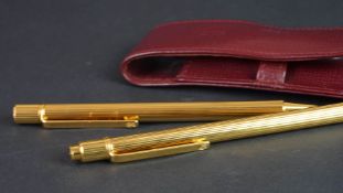 Must de Cartier gold cased ballpoint pen and pencil set, serial numbers H449 and 298917, in fitted