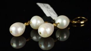 A pair of freshwater pearl earrings, two pearls set from a yellow metal hook, stamped 14k, gross