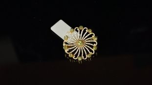 Peridot and enamel pinwheel design brooch, mounted in unmarked yellow metal, with pin and 'C' catch,