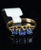 Three stone sapphire ring, set in unhallmarked yellow metal, stamped MG, finger size Q.