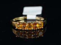 Orange stone ring, set with three light orange stones each separated by two darker orange stones,