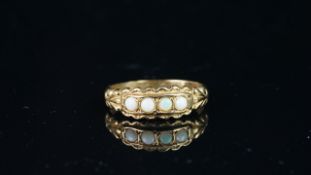Opal four stone ring, four small opals, carved setting and engraved shoulders, in 9ct yellow, ring