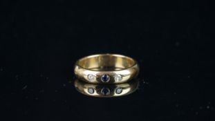 Three stone ring, set with one blue stone and two white stones, flush set, mounted in hallmarked 9ct