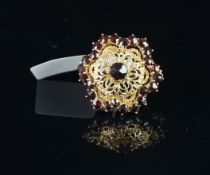 A garnet floral brooch, with a central rose cut garnet, openwork design with a garnet border,