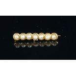 A seed pearl bar brooch, seven seed pearls, in a yellow metal bar, stamped 14, a/f, gross weight