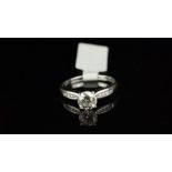 Diamond ring, round brilliant cut diamond weighing an estimated 1.05ct, with channel set round