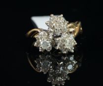 A diamond cluster ring, designed as three daisy clusters, each set with a central round brilliant