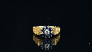 Sapphire and diamond flower shaped cluster ring, mounted in hallmarked 18ct yellow gold, with