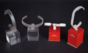 4 OMEGA WATCH DISPLAY STANDS, 2 red black stands (1x short, 1x Tall), with a pair of clear short