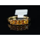 Orange stone ring, set with three light orange stones each separated by two darker orange stones,