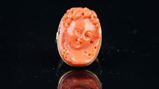 Carved coral cameo ring, mounted in yellow metal stamped 18k, cameo of a young cherub, finger size