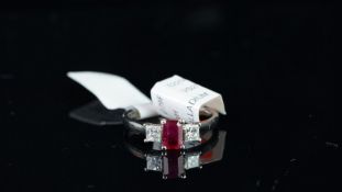 NEW OLD STOCK, UNWORN RETIRED STOCK - A three stone ruby and diamond ring, central emerald cut