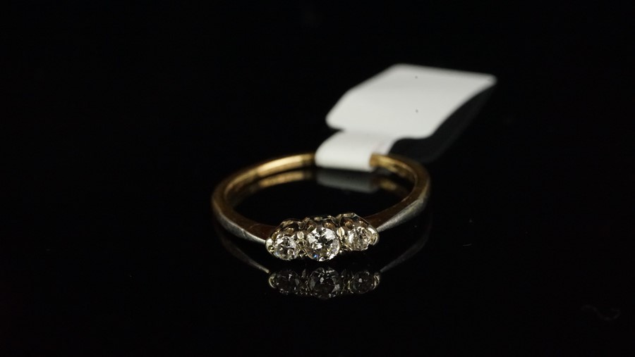 Three stone diamond ring, central old cut diamond with a transitional cut diamond either side,