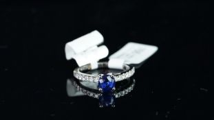 NEW OLD STOCK, UNWORN RETIRED STOCK - A sapphire and diamond ring, central round cut sapphire
