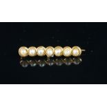 A seed pearl bar brooch, seven seed pearls, in a yellow metal bar, stamped 14, a/f, gross weight