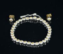 A yellow and white diamond cluster bracelet with matching earrings, thirty-three diamond clusters,