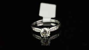 Diamond ring, round brilliant cut diamond weighing an estimated 1.05ct, with channel set round