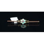 An opal and ruby bar brooch, central round cut ruby surrounded by round cabochon cut opals,