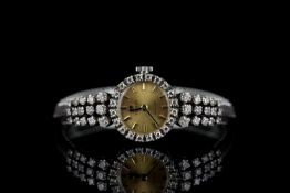 LADIES VINTAGE 14K TISSOT STYLIST WATCH.diamond set bezel and shoulders, round,champagne dial with