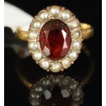 Garnet and split pearl oval cluster ring, mounted in yellow metal, shank stamped 18ct, central