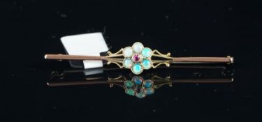 An opal and ruby bar brooch, central round cut ruby surrounded by round cabochon cut opals,
