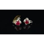 Ruby and diamond screw back ear clips, set in unmarked white metal, central round ruby with