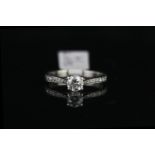 Solitaire ring with diamond shoulders, set with 1 round brilliant cut diamond totalling