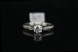 Solitaire ring with diamond shoulders, set with 1 round brilliant cut diamond totalling