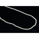 A natural pearl necklace, 2.3mm seed pearls, strung on a gold tone clasp.