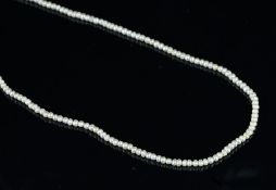 A natural pearl necklace, 2.3mm seed pearls, strung on a gold tone clasp.