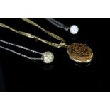 Three chains and necklaces including, 18ct yellow gold oval locket with pierced work front, flat