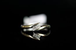 Two stone diamond crossover ring, mounted in white metal stamped 18k, two princess cut diamonds