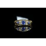 Sapphire and diamond carved half hoop ring, oval cut sapphire centre with four old cut diamonds