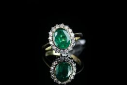 Emerald and diamond cluster ring, set with 1 oval cut emerald, rubover set, surrounded by 16 round