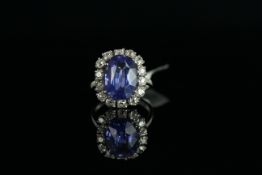 18CT WHITE GOLD SAPPHIRE AND DIAMOND CLUSTER RING. centre stone estimated at 7.5ct, 13.7x10x6mm ,