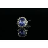 18CT WHITE GOLD SAPPHIRE AND DIAMOND CLUSTER RING. centre stone estimated at 7.5ct, 13.7x10x6mm ,