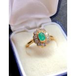 18ct gold diamond and emerald ring set with central emerald that mea5.5mm by 4mm with 10 diamonds a