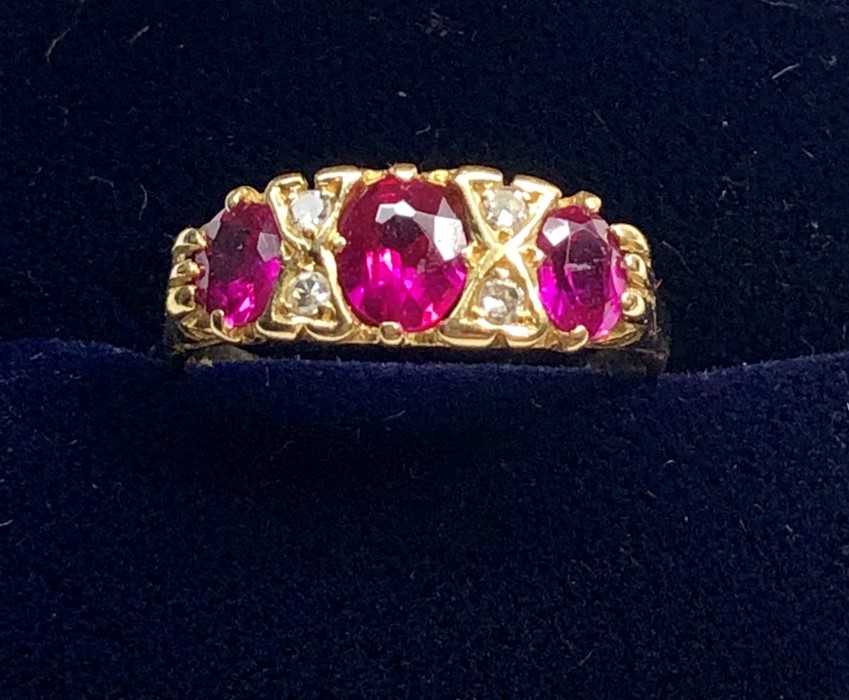 18ct gold diamond and ruby ring set with 3 rubies largest measures approx 5.5mm by 5mm with 4 small