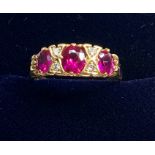 18ct gold diamond and ruby ring set with 3 rubies largest measures approx 5.5mm by 5mm with 4 small