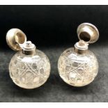 Pair of silver top scent bottles complete with stoppers good uncleaned condition hallmarks worn heig