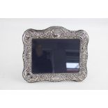Hallmarked 1997 Birmingham silver photograph frame (452g) with scrolling leaf detailing and flower h