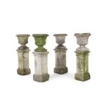 A set of four composite stone urns on square columns, 19th century