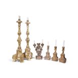 A pair of giltwood candlesticks, 19th century and three other candlesticks